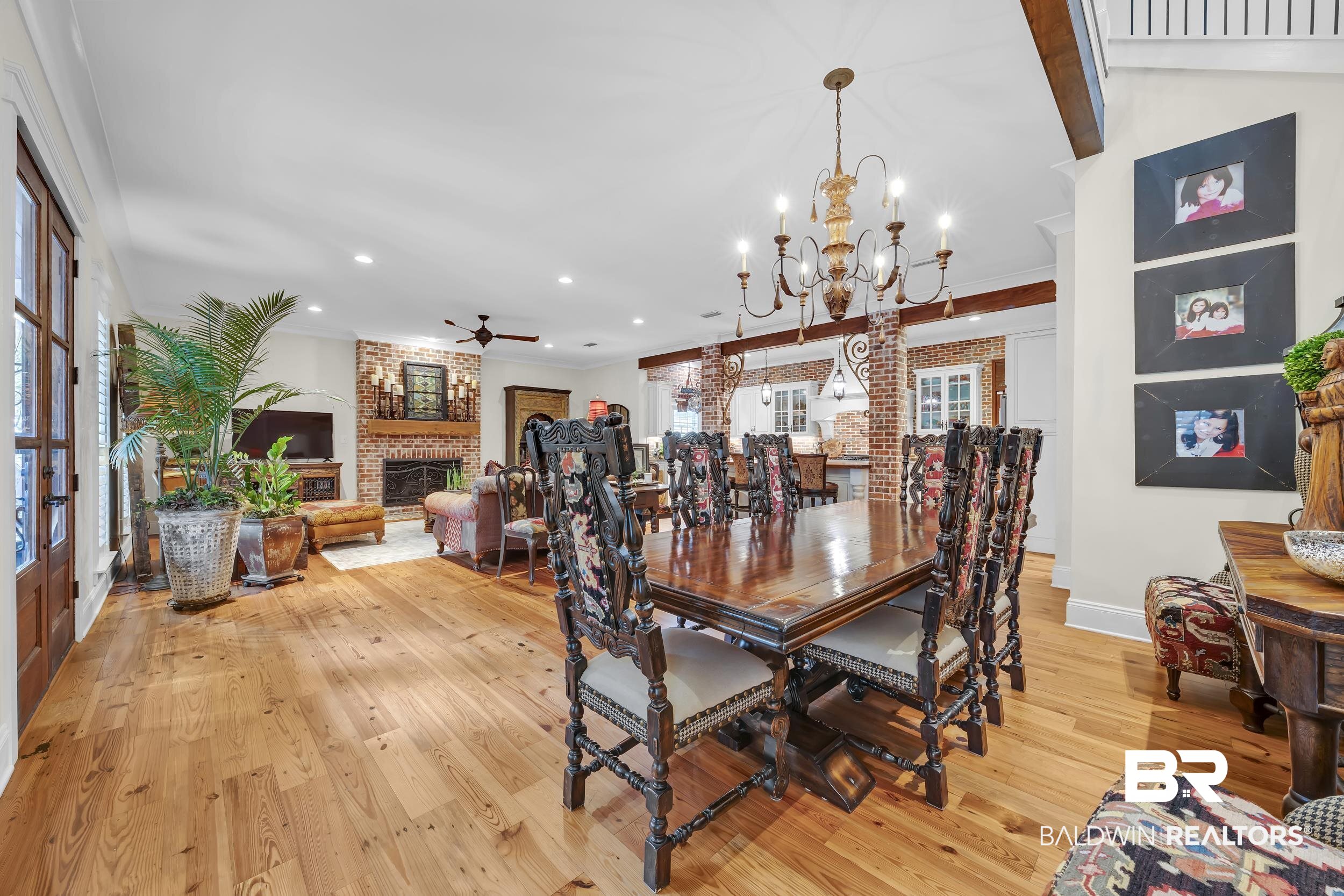 12161 Jessamine Street Magnolia Springs, AL 36555 - Photo 4 of 70 Dining room featuring a brick fireplace, light wood-type flooring, ceiling fan, suspended lighting, and crown molding
