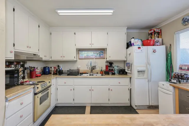 a kitchen with white cabinets and white appliances