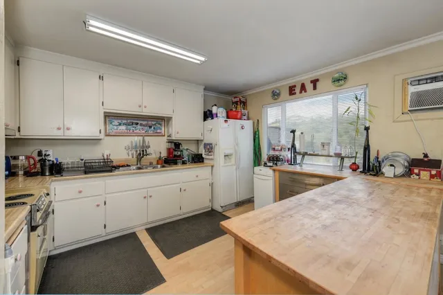 a kitchen with granite countertop white cabinets and white appliances