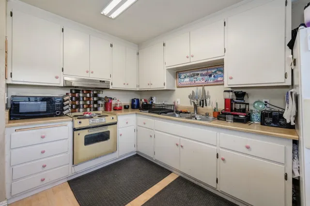 a kitchen with granite countertop white cabinets and white appliances