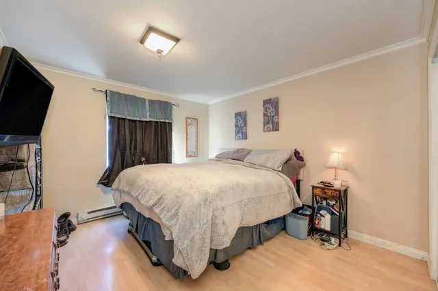 a spacious bedroom with a bed and a flat screen tv