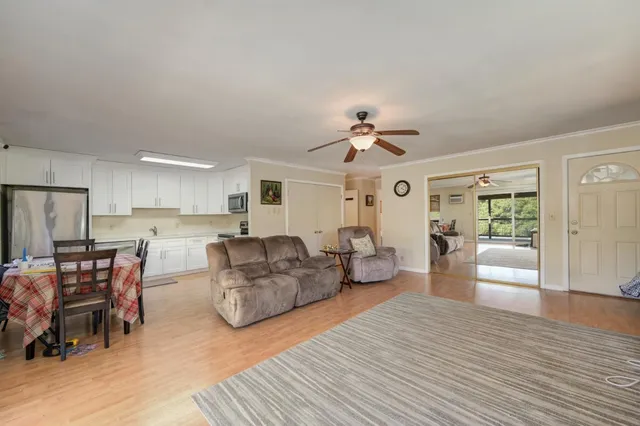 a kitchen with stainless steel appliances granite countertop a stove a refrigerator a white table and chairs