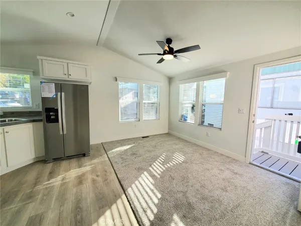 a view of a kitchen with refrigerator and windows
