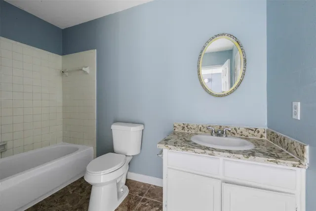 a bathroom with a granite countertop sink a toilet and a mirror