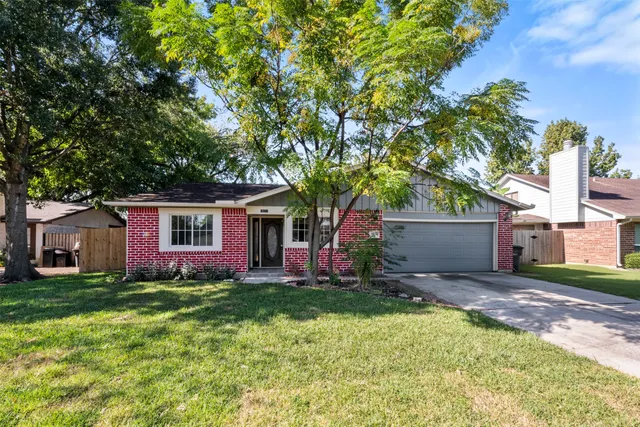 a front view of house with yard and trees in the background