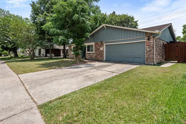 a white house that has tree in front of it