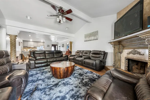 a living room with furniture a flat screen tv and a fireplace