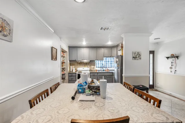 a room with stainless steel appliances kitchen island granite countertop a refrigerator and a stove