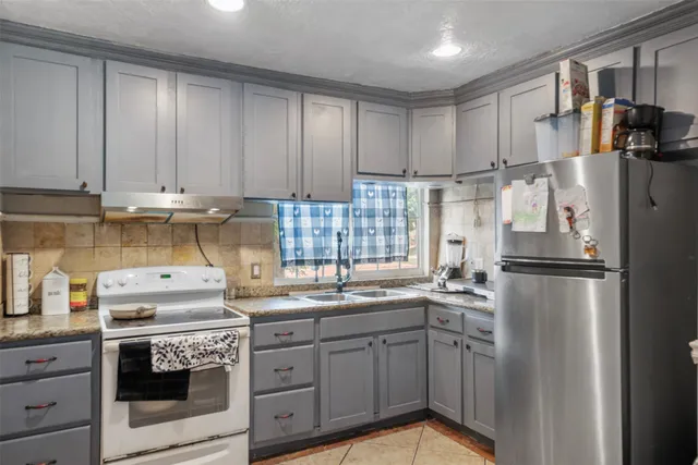 a kitchen with appliances a sink and cabinets