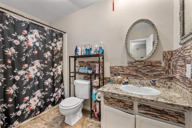 a bathroom with a toilet sink and mirror