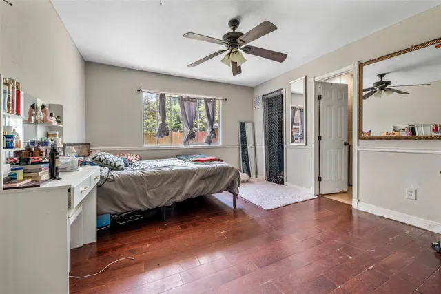 a spacious bedroom with a bed and a ceiling fan