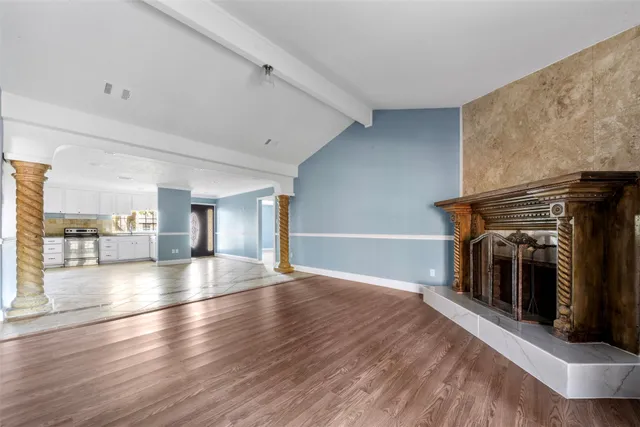 a view of a livingroom with wooden floor and a fireplace