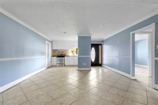 a view of empty room with kitchen and window