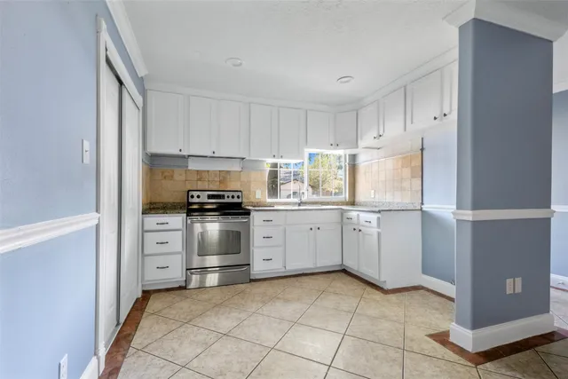 a kitchen with white cabinets and appliances