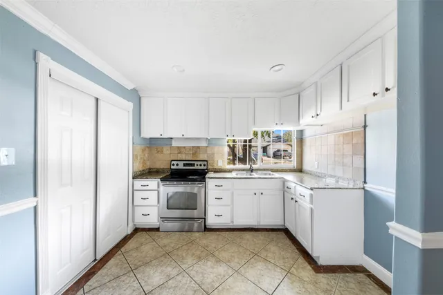 a kitchen with stainless steel appliances granite countertop a refrigerator sink and stove