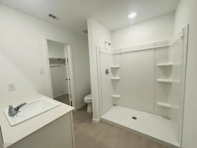 a bathroom with a shower sink and mirror