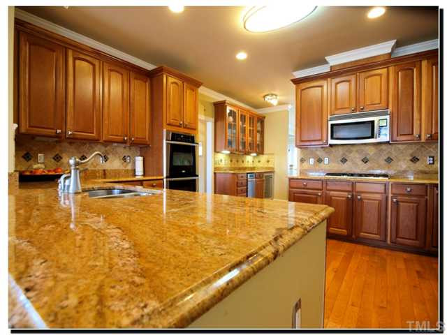 10702 Friendly Neighbor Lane Raleigh, NC 27614 - Photo 6 of 25 Gourmet kitchen with all the upgrades. Double ovens, gas cooktop, upgraded granite, butler's service, wine fridge, and tons of counter space. Kitchen