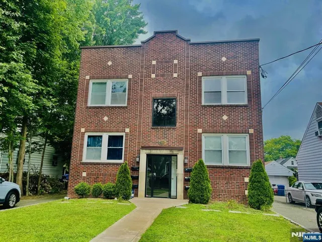 a front view of a house with a garden and yard