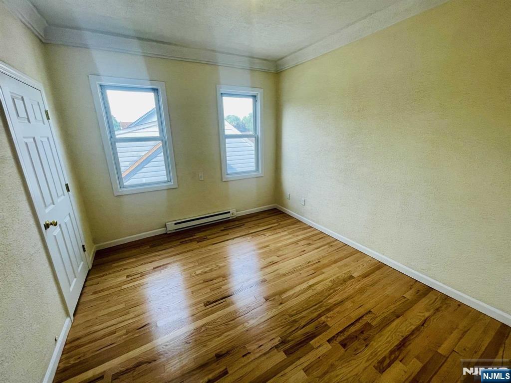 229 Orient Way, Unit 3 Rutherford, NJ 07070 - Photo 14 of 22 a view of empty room with wooden floor and fan