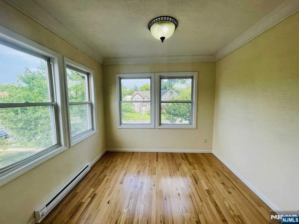 229 Orient Way, Unit 3 Rutherford, NJ 07070 - Photo 17 of 22 an empty room with wooden floor and windows