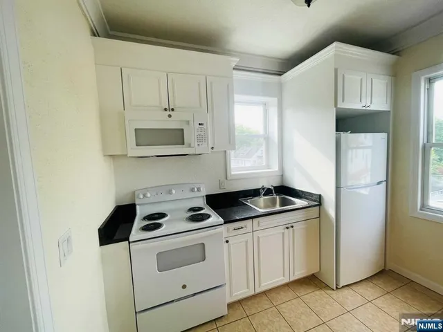 a kitchen with white cabinets and white appliances
