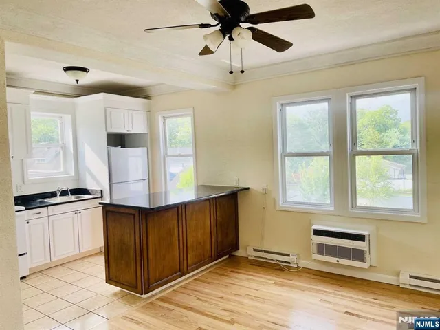 a kitchen with granite countertop a stove a sink and a refrigerator