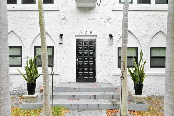 a front view of a house with potted plants