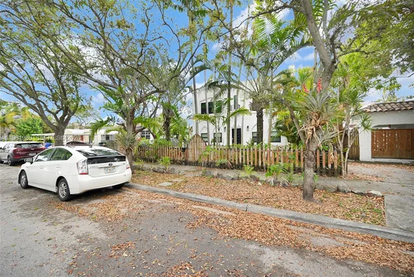 an aerial view of residential houses with outdoor space and trees