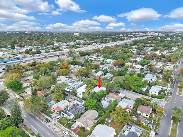 a white house covered with tall trees