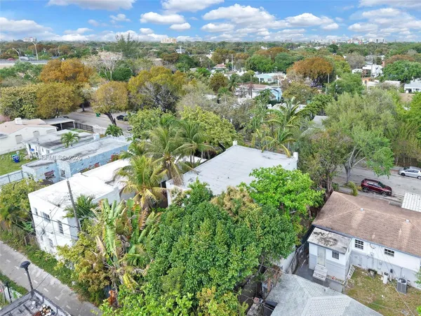 a view of a white house with a large trees