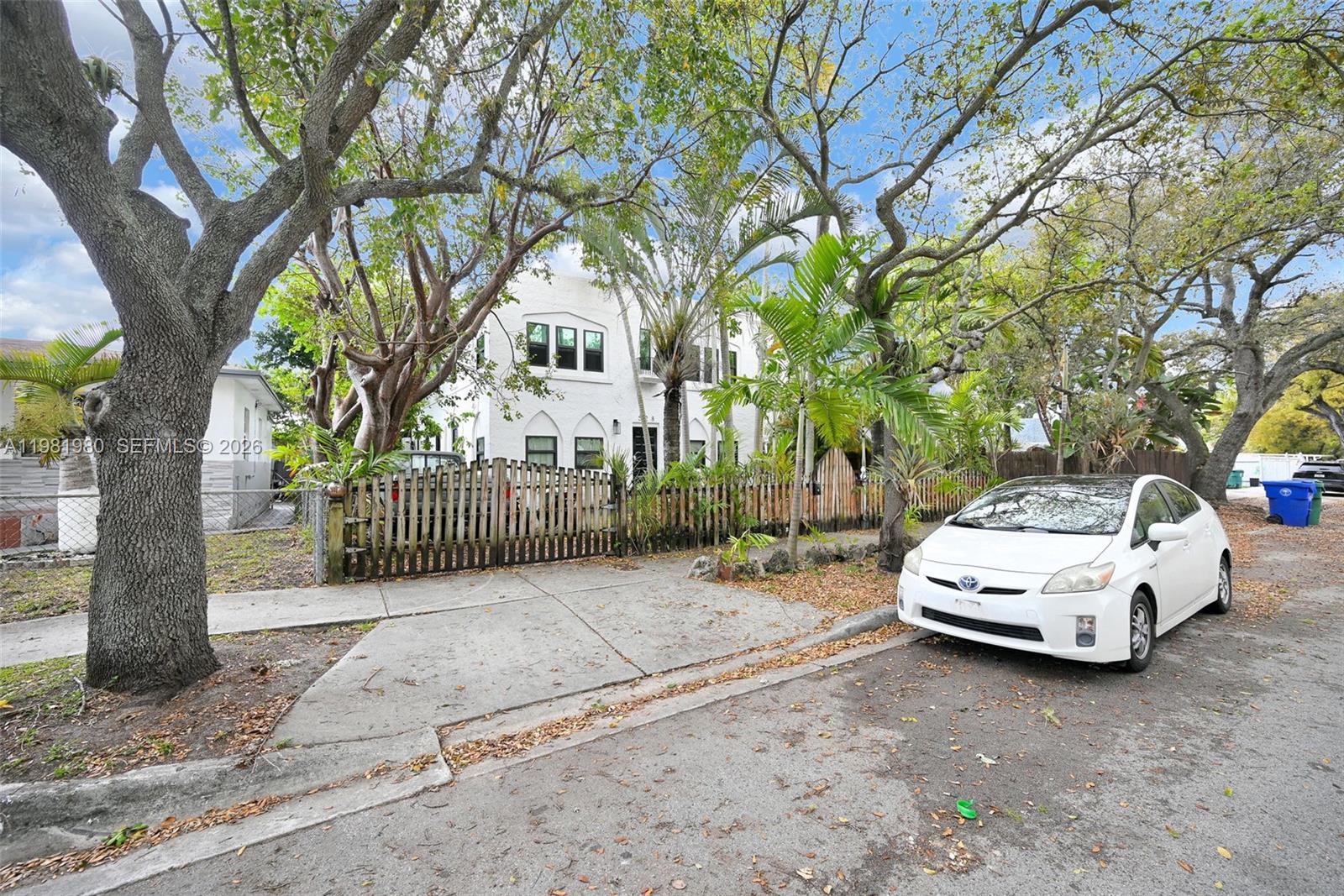 528 Northwest 47th Street, Unit 2 Miami, FL 33127 - Photo 27 of 34 a white house covered with tall trees