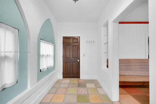 a view of a hallway with wooden floor and a cabinet