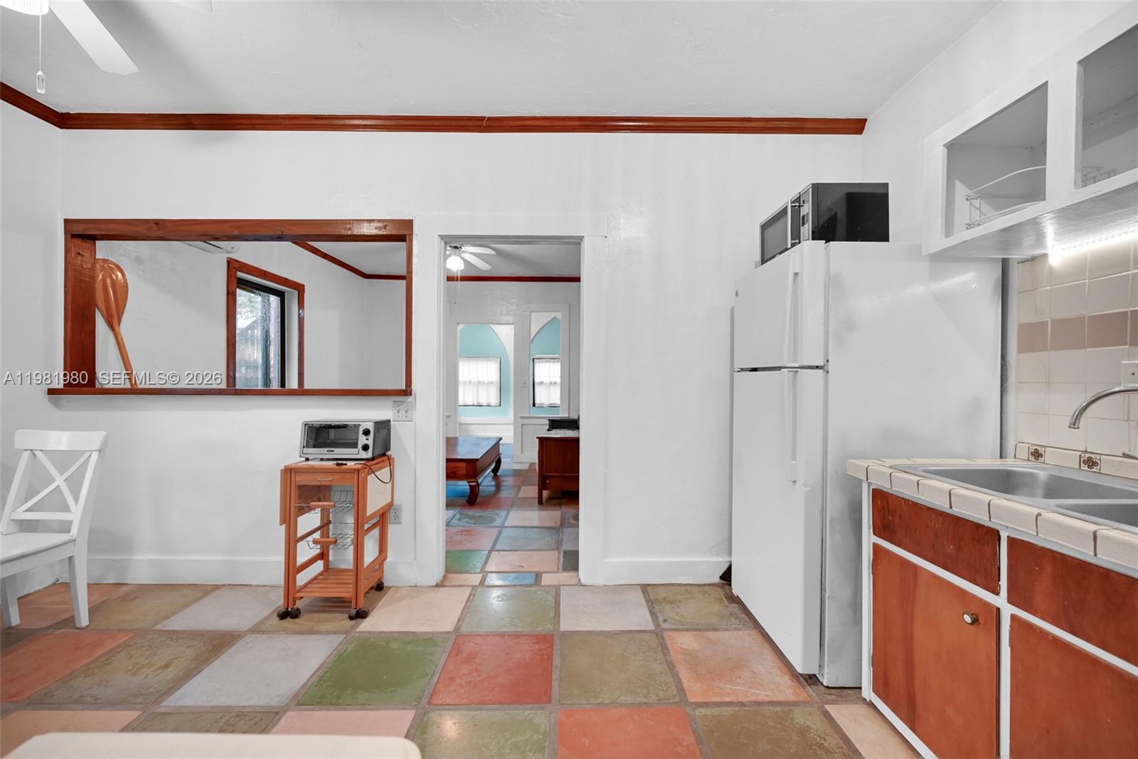 528 Northwest 47th Street, Unit 2 Miami, FL 33127 - Photo 6 of 34 a view of a hallway with wooden floor and a cabinet