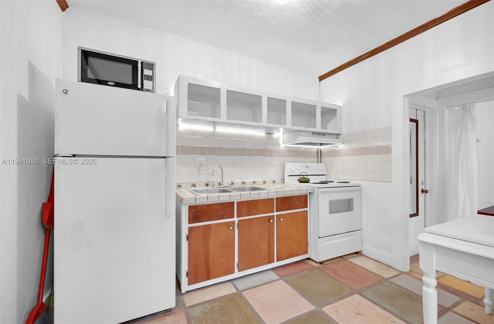 528 Northwest 47th Street, Unit 2 Miami, FL 33127 - Photo 7 of 34 a kitchen with stainless steel appliances a refrigerator stove and sink