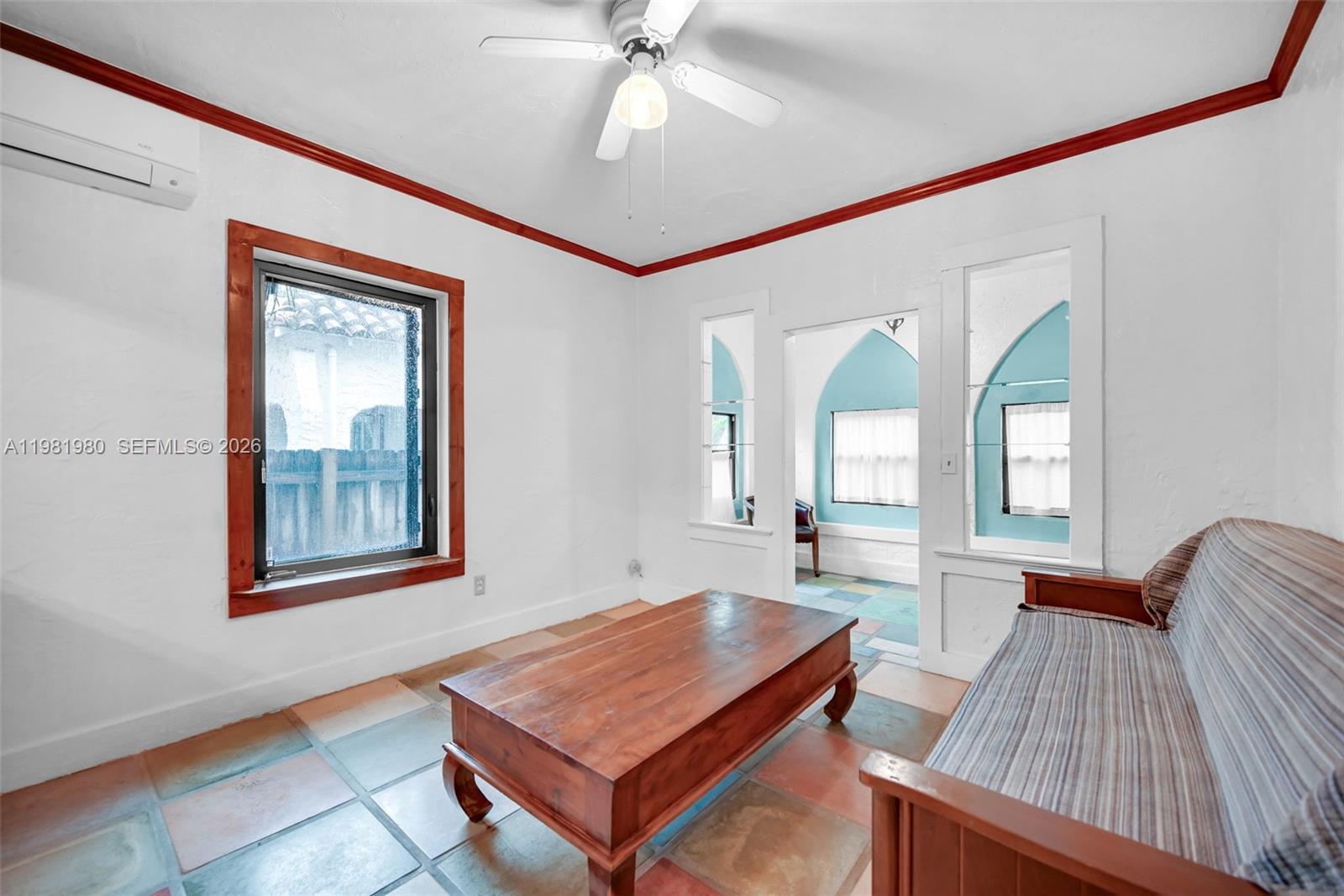 528 Northwest 47th Street, Unit 2 Miami, FL 33127 - Photo 10 of 34 a living room with a table and paintings on the wall