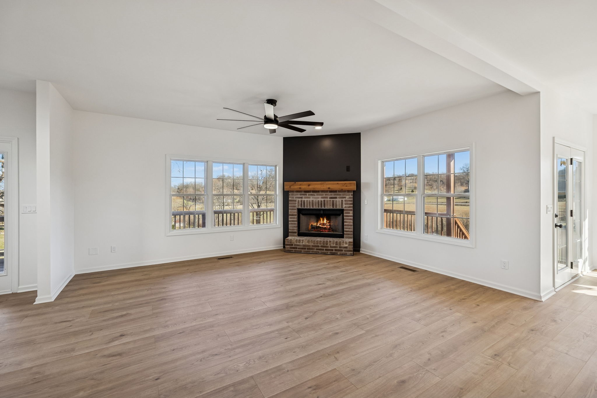 1909 Evergreen Road Thompson's Station, TN 37179 - Photo 12 of 75 an empty room with windows a fireplace and wooden floor