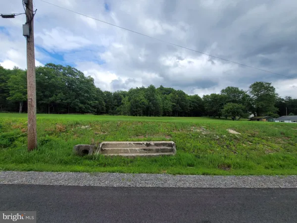 a view of a park with of a house in the background
