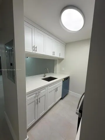 a kitchen with stainless steel appliances granite countertop white cabinets and a stove top oven