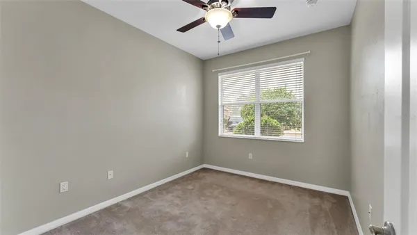 an empty room with chandelier fan