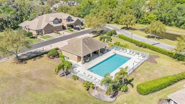 an aerial view of a house with a yard and large trees
