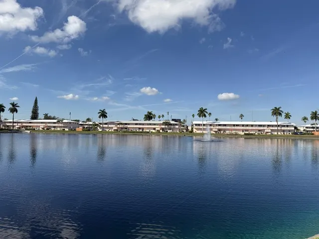 a view of an ocean with boats and trees in the background