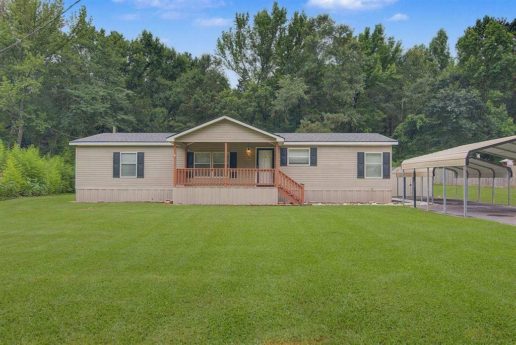 1202 Princeton Road Princeton, LA 71067 - Photo 2 of 19 Single-story residence featuring light-colored siding, a covered porch with wood railings, a dark shingle roof, and dark window shutters