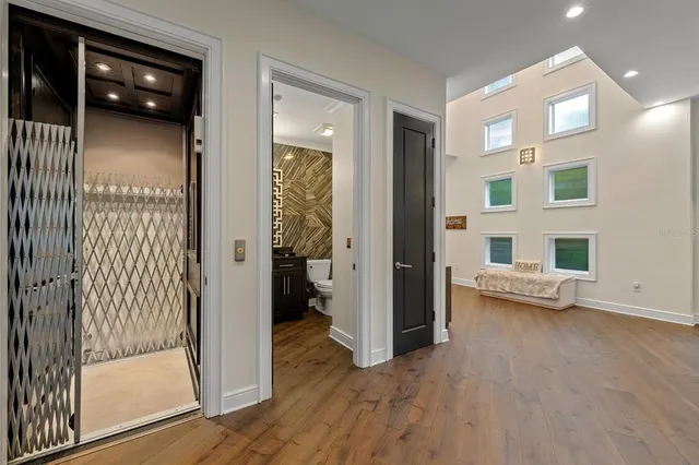 a view of a hallway with wooden floor and staircase