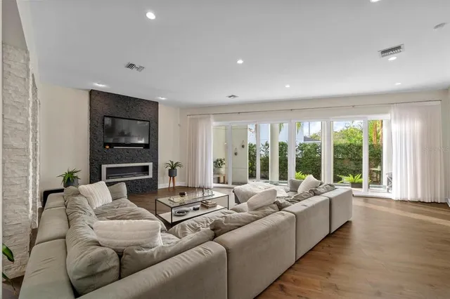 a living room with furniture floor to ceiling window and wooden floor