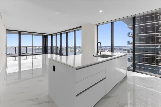 a large white kitchen with a large window