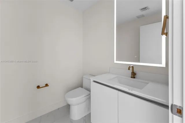 a bathroom with a granite countertop sink a toilet and a mirror