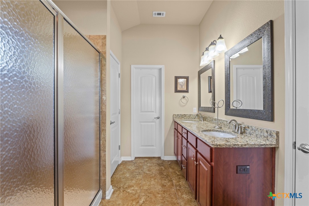20525 Jackies Ranch Boulevard Pflugerville, TX 78660 - Photo 18 of 30 Full bathroom with double vanity and oversized shower with upper window for light. Walk in closet, storage, and separate room for toilet.