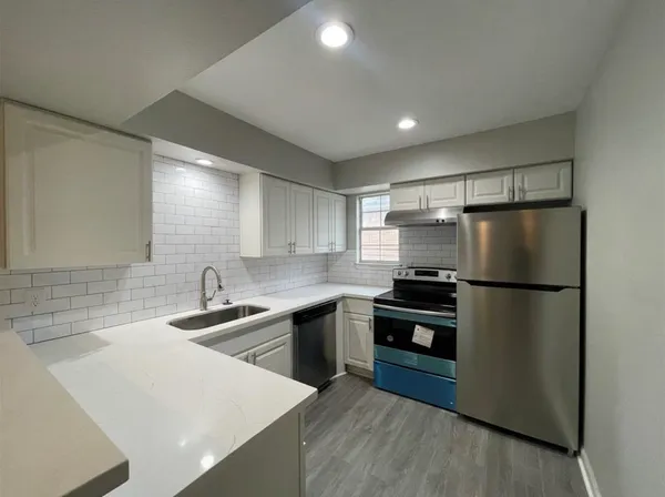 a kitchen with kitchen island a sink stainless steel appliances and cabinets