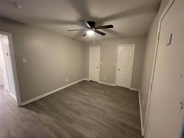 an empty room with closet and windows