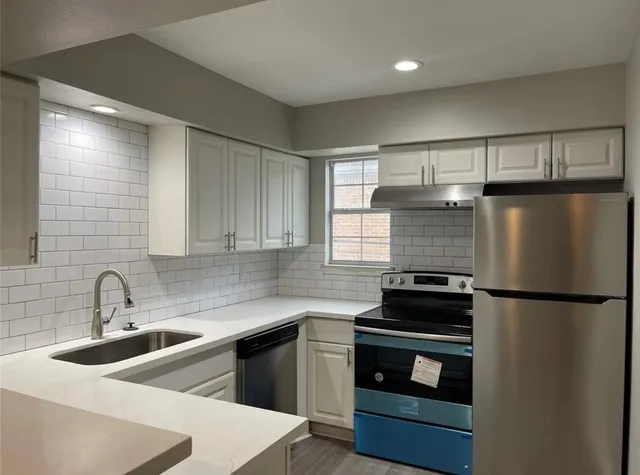 a kitchen with a sink and white stainless steel appliances